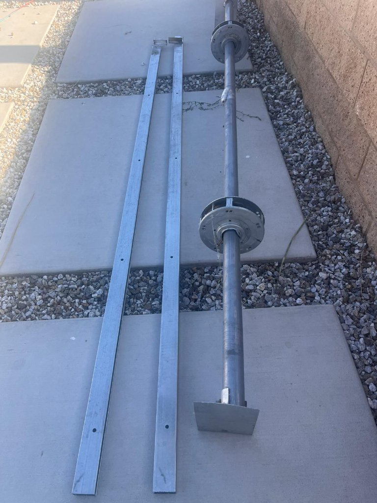 New garage door torsion shaft and vertical tracks ready for installation during a cable and hardware repair in Los Angeles