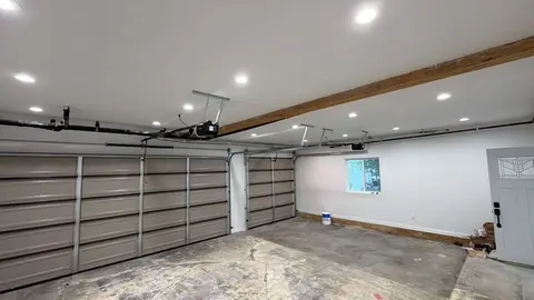 Interior view of a two-car garage with two freshly installed LiftMaster belt drive openers and LED lighting