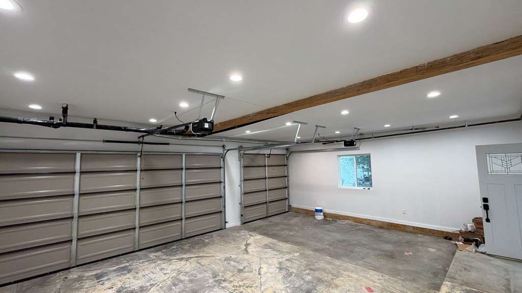 Interior view of two-car garage showing freshly installed LiftMaster openers with LED lighting system